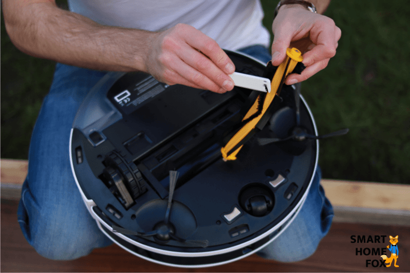 Cleaning the main brush of the Ecovacs Deebot N8+ with the supplied cleaning tool.